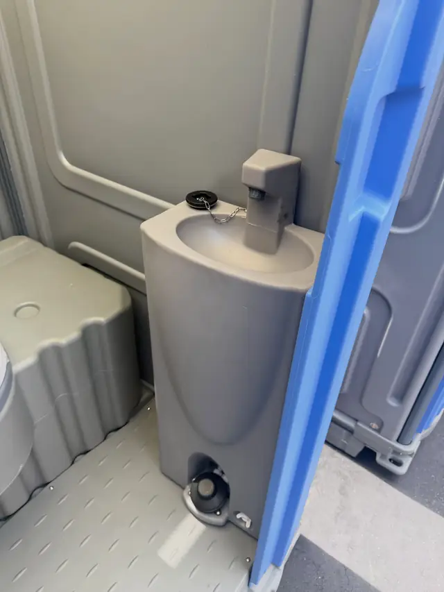 Foot-pump sink inside a deluxe flushing porta potty