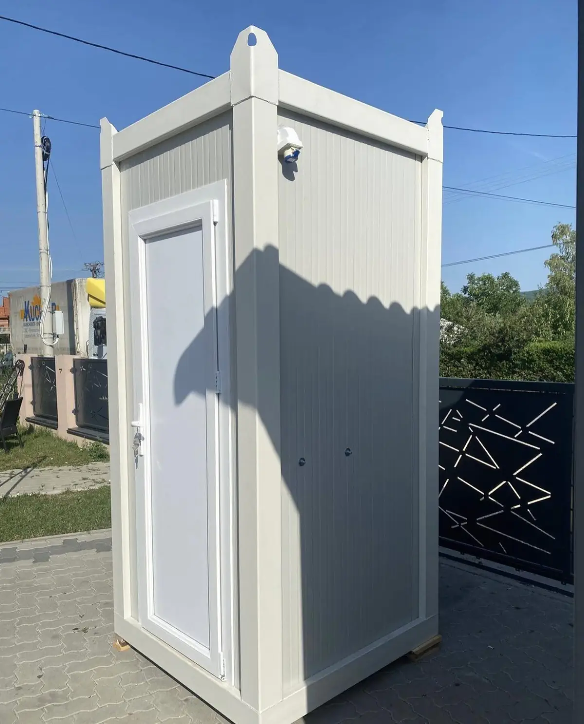 Side view of a white luxury restroom cabin on pavement