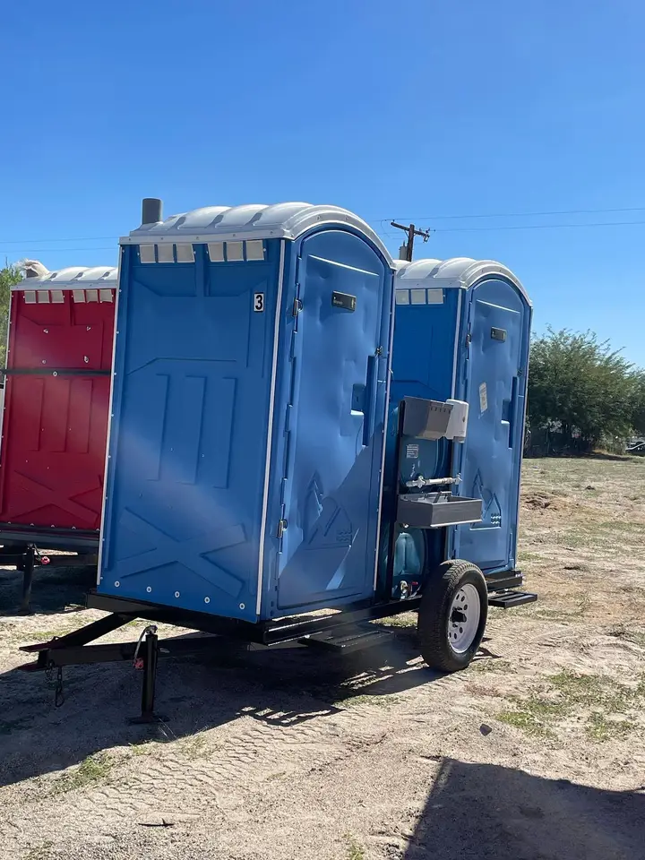 Blue porta potties strapped on a delivery trailer